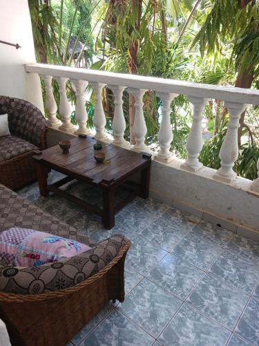 a balcony with a table and a white railing at Hildas Studio in Diani Beach