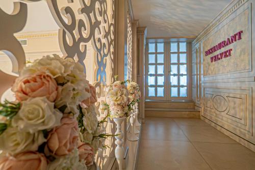 a hallway with flowers on the walls of a building at Hotel Sulina International in Mamaia