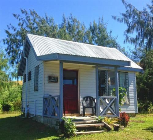 mały biały dom z czerwonymi drzwiami w obiekcie Bay of Plenty Nature Lodge w mieście Nanuya Lailai