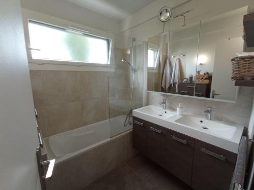 ein Bad mit einer Badewanne, einem Waschbecken und einer Dusche in der Unterkunft Appartement 6 personnes 100 m2 in Chatou