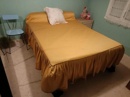 un lit avec un drap jaune dessus dans l'établissement maison dans hameau 6 km de la mer, à Pornic