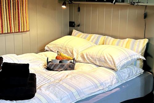 a bed with pillows and a bowl of fruit on it at Ett roms leilighet Vestvågøy in Gravdal