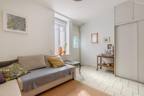 un salon avec un canapé et une fenêtre dans l'établissement La Joséphine - Maison avec terrasse, à Saint-Gilles-Croix-de-Vie