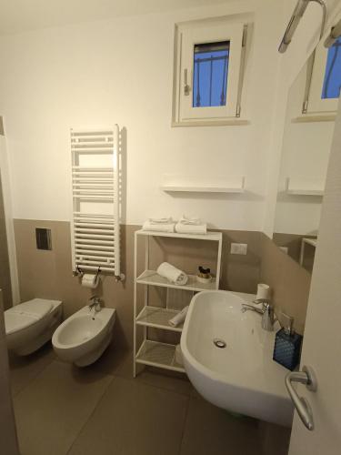 a white bathroom with a sink and a toilet at L'Affaccio in Matera