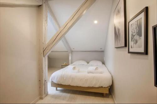 um quarto com uma cama branca com duas toalhas em Mermoz/Deauville : Superbe Appartement em Deauville