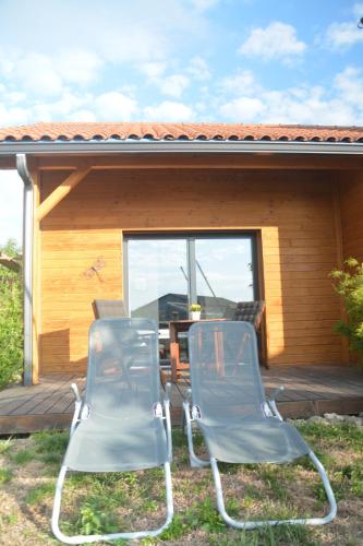 two chairs sitting on the deck of a cabin at Les Condamines in Antoingt