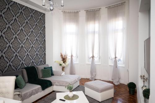 a living room with a couch and two windows at Apartment Primula in Subotica