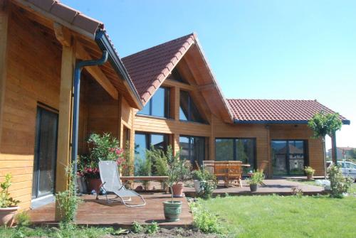 a house with a deck with a chair on it at Les Condamines in Antoingt