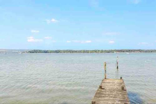 a dock in the water with a view of the ocean at Lilliput Hideaway 5 mins from Sandbanks Beach in Parkstone