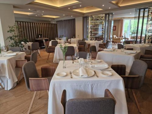 a restaurant with tables and chairs with white tablecloths at Gran Hotel Balneario De Puente Viesgo in Puente Viesgo