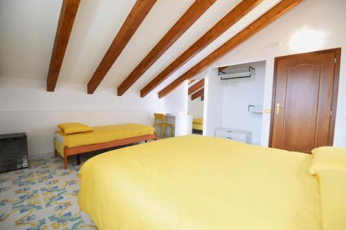 a bedroom with a yellow bed and a cabinet at B&B IL BIVIO SUI SENTIERI in Pianillo