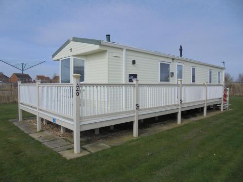 a white mobile home with a white fence at 8 Berth on The Chase (Bermuda) in Ingoldmells
