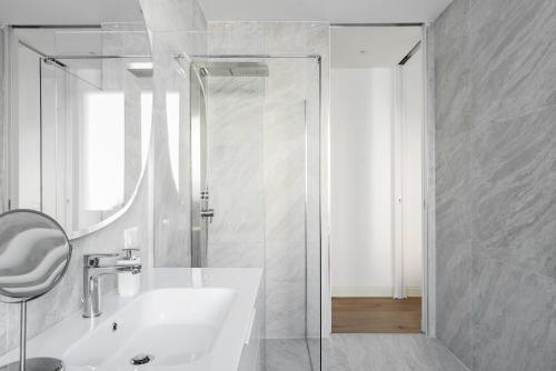 een witte badkamer met een wastafel en een douche bij Pure White - by MyHomeInComo in Como