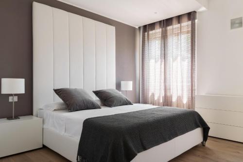 een slaapkamer met een groot bed en een groot raam bij Pure White - by MyHomeInComo in Como