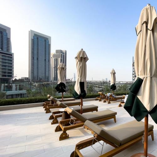 a row of lounge chairs and umbrellas on a roof at Luxury apartments at Vida Residences in Dubai