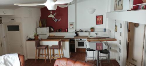 - une petite cuisine avec un comptoir et des tabourets dans l'établissement LOFT VICTOR HUGO, à Carcassonne