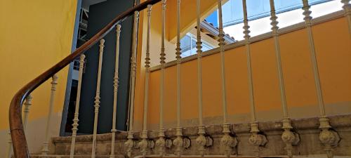 un escalier avec une paroi jaune et une rampe métallique dans l'établissement LOFT VICTOR HUGO, à Carcassonne