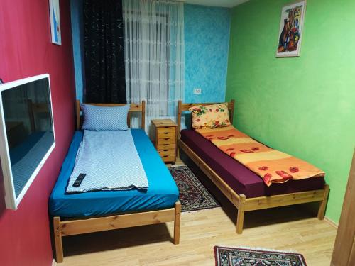 2 camas en una habitación con paredes verdes y rojas en La Paula für Monteure, en Altenmedingen