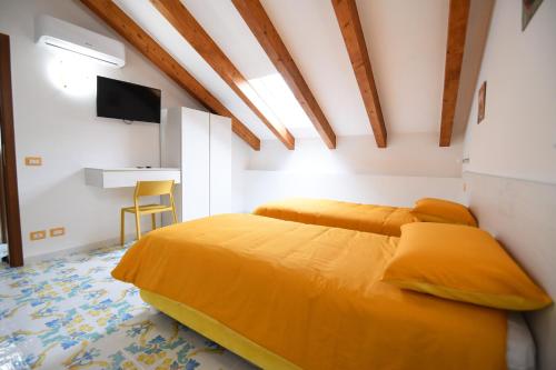 a bedroom with two beds with yellow pillows at B&B IL BIVIO SUI SENTIERI in Pianillo