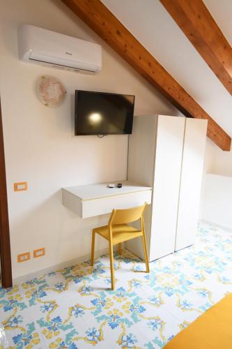 a room with a desk and a chair and a tv at B&B IL BIVIO SUI SENTIERI in Pianillo