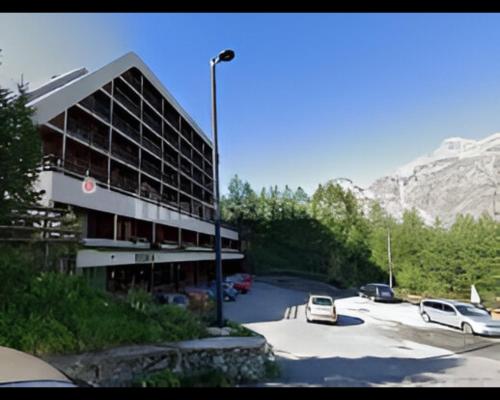 a building with cars parked in a parking lot at Condominio La Grand'Ourse - Cervinia in Breuil-Cervinia