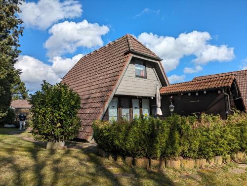 uma casa com um telhado castanho e alguns arbustos em Haus Paradiesecke em Waldbrunn
