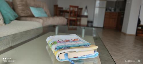 uma pilha de toalhas numa mesa de vidro numa sala de estar em Любимото синьо в Синеморец em Sinemorets