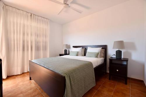 a bedroom with a bed and a ceiling fan at Hygge Home with Seaside and Golf-View Balcony in San Miguel de Abona