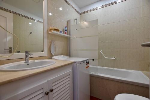 a bathroom with a sink and a toilet and a tub at Hygge Home with Seaside and Golf-View Balcony in San Miguel de Abona