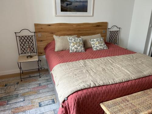 une chambre avec un grand lit avec des draps et des oreillers rouges dans l'établissement Petite Pépite du Suquet, à Cannes