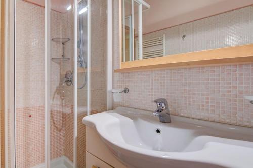 uma casa de banho com um lavatório e um chuveiro em Azzurro Apartment em Padenghe sul Garda