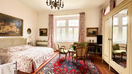 um quarto com uma cama, uma secretária e cadeiras em Burg Satzvey em Mechernich