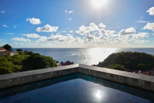una piscina con vista sull'oceano di Hôtel Barrière Le Carl Gustaf St Barth a Gustavia