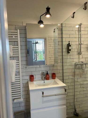 une salle de bain blanche avec un lavabo et une douche dans l'établissement Petite Pépite du Suquet, à Cannes