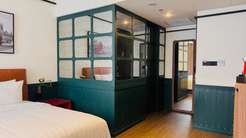 a bedroom with a green cabinet with glass windows at Ashley Tugu Tani Menteng in Jakarta