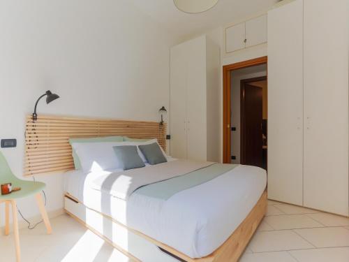 een slaapkamer met een groot wit bed en een tafel bij The Best Rent - Corso Buenos Aires Apartment in Milaan