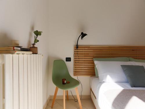 een slaapkamer met een groene stoel naast een bed bij The Best Rent - Corso Buenos Aires Apartment in Milaan
