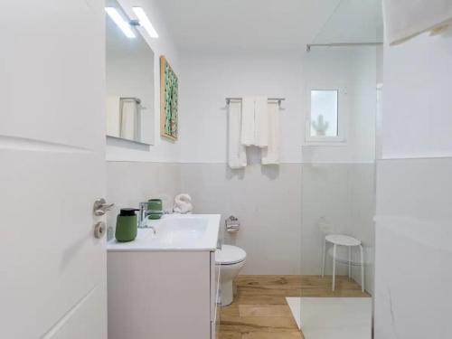 ein weißes Bad mit einem WC und einem Waschbecken in der Unterkunft Elegante apartamento 5 min de playa in San Bartolomé de Tirajana