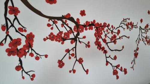 a branch of a tree with red flowers on it at Appartamento Vista Panoramica in Agrate Brianza