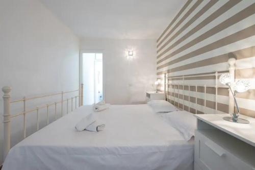 ein weißes Schlafzimmer mit einem Bett mit zwei Handtüchern darauf in der Unterkunft Amplio Apartamento en el centro in San Bartolomé de Tirajana