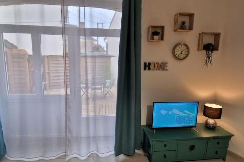a laptop sitting on a dresser next to a window at LE CHATEL BOURGEOIS in Appoigny