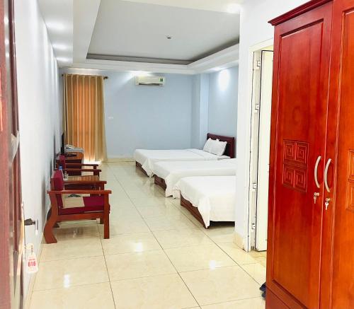 Cette chambre comprend 2 lits et une table. dans l'établissement Bach Duong Hotel, à Hanoï