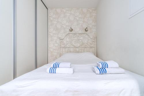 uma cama branca com toalhas azuis e brancas em Angel House Vilnius, Skroblu 39 em Vilnius