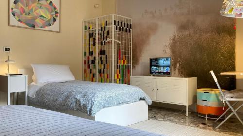 a bedroom with a bed and a tv in it at Three Rooms in Messina