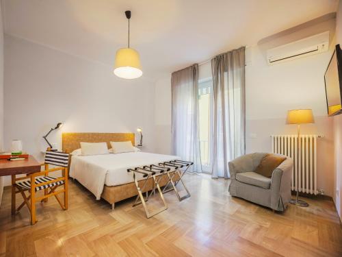 a bedroom with a bed and a table and a chair at La Casa delle Acciughe Guest House in La Spezia