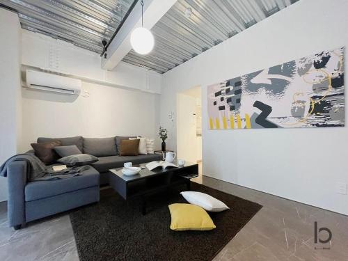 a living room with a couch and a table at bHOTEL Komachi - BREAKFAST Included - Central Stay in Hiroshima