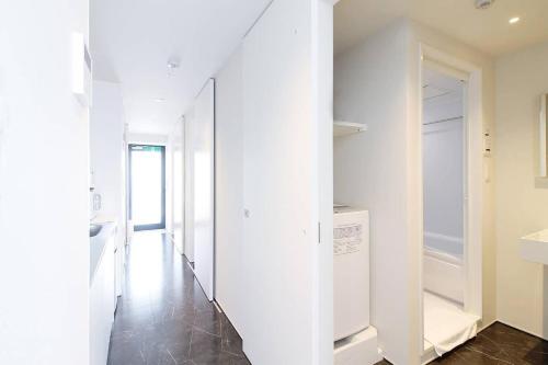 a hallway with white walls and a washer and dryer at bHOTEL Komachi - Apt for 6ppl few mins walk to Peace Park in Hiroshima