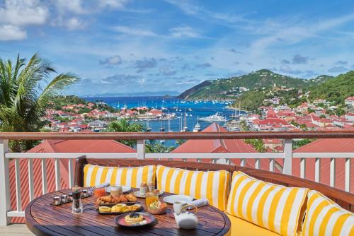 una mesa con una bandeja de comida en el balcón en Hôtel Barrière Le Carl Gustaf St Barth, en Gustavia