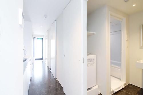 pasillo con paredes blancas, lavadora y secadora en bHOTEL Komachi - New Apt for 6ppl close to the PeacePark en Hiroshima