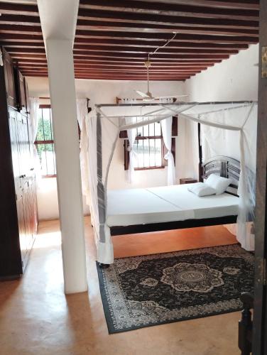 a bedroom with a bed with a canopy at Subira Guest House in Lamu